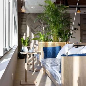 una habitación con un banco y una mesa con plantas en Hilton Garden Inn Le Havre Centre, en Le Havre