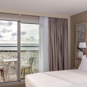 a bedroom with a bed and a view of the ocean at Hilton Garden Inn Le Havre Centre in Le Havre