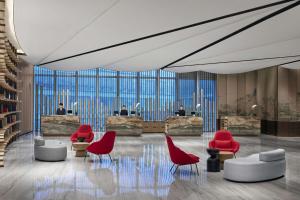 a rendering of a lobby with red chairs and desks at Conrad Shanghai in Shanghai