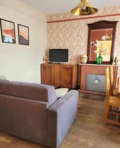 salon z kanapą i telewizorem w obiekcie Gîte Moussette - Bord de Mer - 4/6 pers. w mieście Quinéville