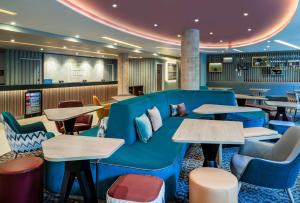 a lobby with a blue couch and tables at Hampton By Hilton Bath City in Bath