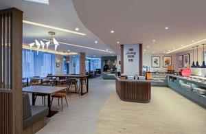 a restaurant with tables and chairs and a bar at Hampton By Hilton Bath City in Bath