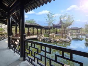 - une vue sur le jardin depuis un bâtiment avec un étang dans l'établissement Doubletree By Hilton Yancheng Dayangwan, à Yancheng