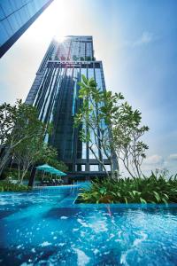 a tall building with a swimming pool in front of it at Doubletree By Hilton Shah Alam I-City in Shah Alam