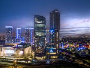 a city skyline at night with tall buildings at Doubletree By Hilton Shah Alam I-City in Shah Alam