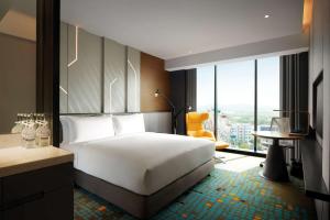 a hotel room with a bed and a desk and a window at Doubletree By Hilton Shah Alam I-City in Shah Alam