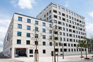 雷根斯堡Hampton By Hilton Regensburg的一栋白色建筑，前面有树