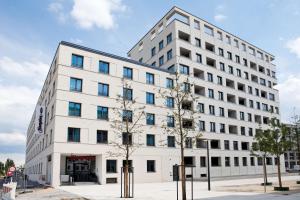 a large white building with blue windows at Hampton By Hilton Regensburg in Regensburg