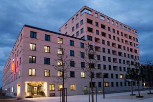 a large white building with lights on at Hampton By Hilton Regensburg in Regensburg