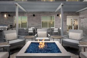 um pátio com uma fogueira, cadeiras e comodidades para churrascos em Homewood Suites By Hilton Destin em Destin