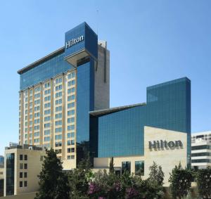 ein Gebäude mit einem Schild auf dem Hügel in der Unterkunft Hilton Amman in Amman