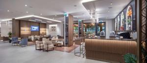 a restaurant with a bar and tables and chairs at Doubletree By Hilton Plovdiv Center in Plovdiv