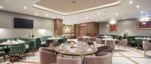 a restaurant with tables and chairs and a flat screen tv at Doubletree By Hilton Plovdiv Center in Plovdiv