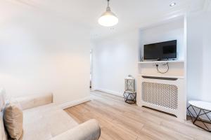 a living room with a couch and a tv at The High Street Kensington Boutique in London