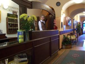 a woman standing behind a counter in a store at Hotel Barbakan in Levoča