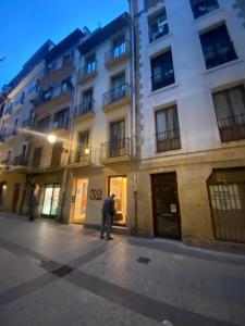 a man standing on a street in front of a building at 32 De Agosto ROOMS in San Sebastián