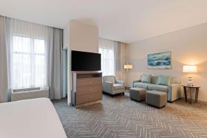Homewood Suites By Hilton Panama City Beach, Fl في بنما سيتي بيتش: غرفة فندقية بسرير وتلفزيون بشاشة مسطحة