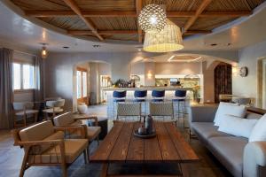 un soggiorno con divano e tavolo di Sea Breeze Santorini Beach Resort, Curio By Hilton a Perivolos