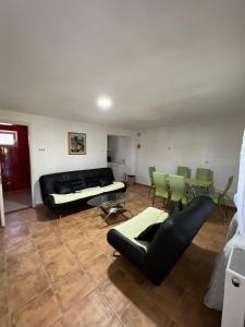 - un salon avec un canapé, une table et des chaises dans l'établissement Casa Orange, à Malo Središte
