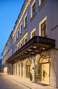 a large building with a balcony on a street at Hotel Saski Krakow Curio Collection by Hilton in Kraków