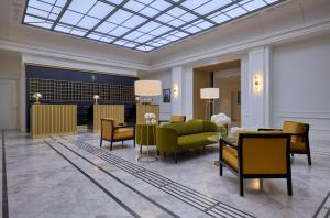 a lobby with a green couch and chairs at Hotel Saski Krakow Curio Collection by Hilton in Krakow