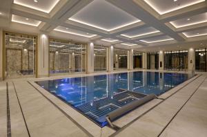 a large swimming pool in a building with a ceiling at Hotel Saski Krakow Curio Collection by Hilton in Kraków