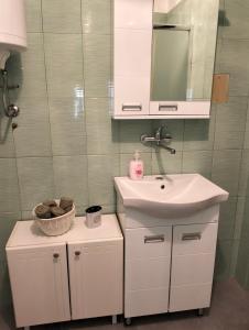 La salle de bains blanche est pourvue d'un lavabo et d'un miroir. dans l'établissement Casa Orange, à Malo Središte