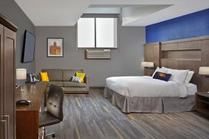 um quarto de hotel com uma cama e um sofá em Scholar Morgantown, Tapestry Collection by Hilton em Morgantown