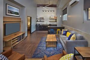 a living room with a couch and a tv at Scholar Morgantown, Tapestry Collection by Hilton in Morgantown