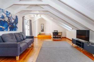 a living room with a couch and a flat screen tv at Hout Bay Gem - Elise Way in Hout Bay