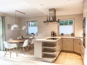 a kitchen with a table and chairs and a counter top at Reethaus Am Mariannenweg 18b - Huus in Boltenhagen