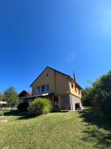 une grande maison sur une colline avec une cour herbeuse dans l'établissement Casa Orange, à Malo Središte