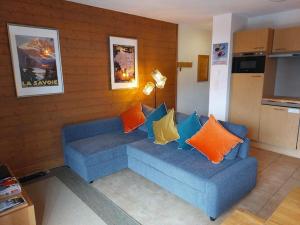 a living room with a blue couch with pillows at La Reine des Prés in Sainte-Foy-Tarentaise