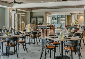 a restaurant with tables and chairs in a room at Coast Rehoboth Beach, Tapestry Collection By Hilton in Rehoboth Beach