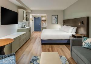 um quarto de hotel com uma cama e um sofá em Coast Rehoboth Beach, Tapestry Collection By Hilton em Rehoboth Beach