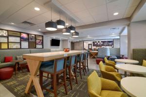 a restaurant with tables and chairs and a bar at Hampton Inn Lincoln White Mountains in Lincoln