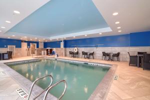 a pool with chairs and tables in a hotel room at Hampton Inn Lincoln White Mountains in Lincoln