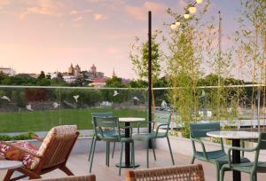 a patio with tables and chairs and a view of the city at Hilton Garden Inn Evora in Évora
