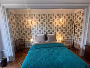Schlafzimmer mit einem Bett mit blauer Decke in der Unterkunft Le Faubourg 29 in Neuenburg