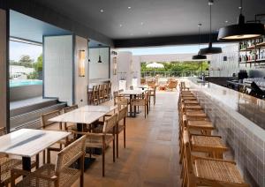 un restaurante con mesas y sillas y una piscina en Hilton Garden Inn Evora, en Évora