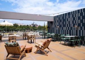 un patio con mesas y sillas en la azotea en Hilton Garden Inn Evora, en Évora