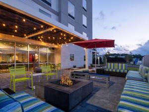 a patio with a fire pit and a building at Home2 Suites By Hilton Santa Rosa Beach in Santa Rosa Beach