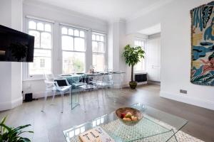 倫敦的住宿－Modern and Bright Highgate Gem，客厅配有玻璃桌和椅子