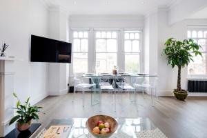 a living room with a glass table with a bowl of fruit at Modern and Bright Highgate Gem in London