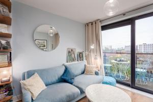 a living room with a blue couch and a window at Bright and Stylish Kennington Gem in London