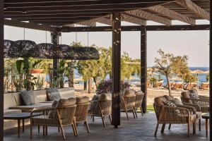 eine Terrasse mit Stühlen, einem Tisch und einem Sofa in der Unterkunft Lindian Village Beach Resort, Curio Collection By Hilton in Kiotari