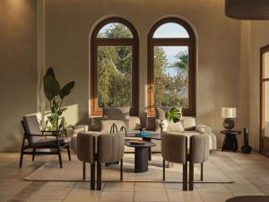 sala de estar con 2 ventanas, sofá y sillas en Lindian Village Beach Resort, Curio Collection By Hilton en Kiotari