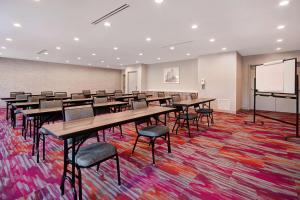 une salle de classe avec des tables et des chaises et un écran de projection dans l'établissement Home2 Suites By Hilton Shepherdsville Louisville South, à Shepherdsville