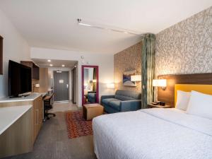 a hotel room with a bed and a living room at Home2 Suites By Hilton Santa Rosa Beach in Santa Rosa Beach