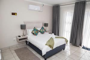 a bedroom with a bed with pillows on it at Faces Guesthouse La Provance in Bethlehem